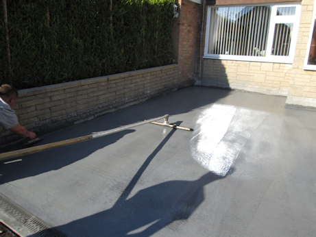 Colour hardener being spread across the concrete
